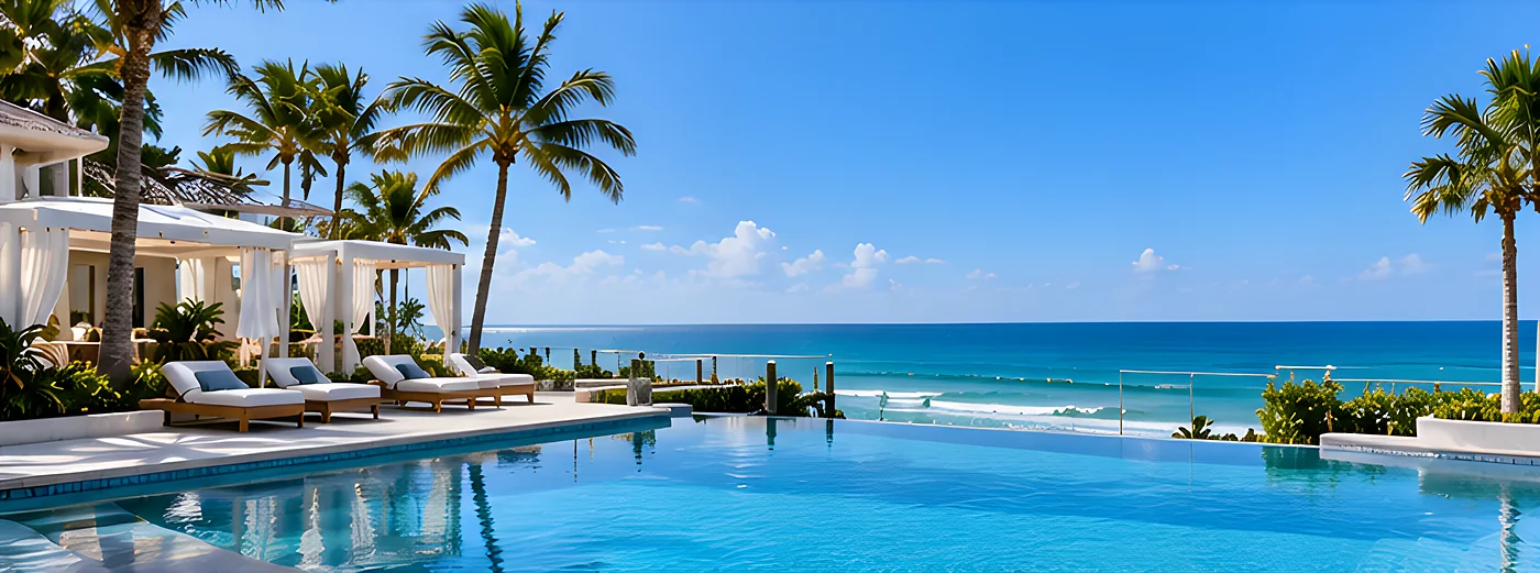 Resort-style oceanfront pool deck with cabanas and palms